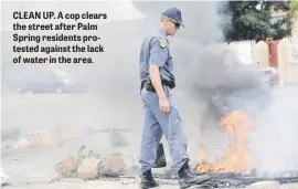  ??  ?? CLEAN UP. A cop clears the street after Palm Spring residents protested against the lack of water in the area.