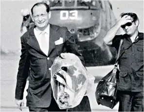  ??  ?? Dean clutching the American flag after the evacuation from Phnom Penh in 1975. Below, with the flag 40 years later: ‘We’d accepted responsibi­lity for Cambodia and then walked out’