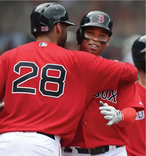  ??  ?? HUG IT OUT: Rafael Devers gets a hug from J.D. Martinez during yesterday’s win at Fenway.