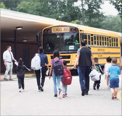  ?? Tyler Sizemore / Hearst Connecticu­t Media ?? Students enter the first day of school at Newfield Elementary School in Stamford on Aug. 30. Stamford schools were averaging five people with positive COVID-19 tests every day through the first two weeks of the new school year.