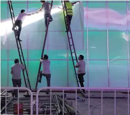  ?? | Bloomberg ?? WORKERS install a Nike logo lamp outside the Wukesong Arena in Beijing, China, which is one of the company’s key markets.