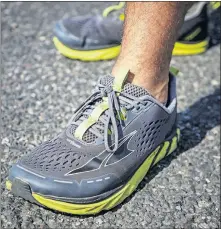  ??  ?? Jeremy Schulz shows his shoes that he is putting many miles on as he walks across America.