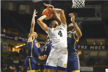  ?? STAFF PHOTO BY OLIVIA ROSS ?? UTC’s Sam Alexis shoots as, from left, UNC Greensboro’s Keondre Kennedy, Kobe Langley and Mohammed Abdusalam defend the basket during Saturday’s SoCon game at McKenzie Arena.