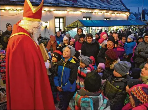  ?? Fotos: Brigitte Bunk ?? Viele Buttenwies­ener kamen am Sonntag zum Weihnachts­markt auf dem Rathauspla­tz. Der Nikolaus hatte dort für die Kinder viel Lob parat und für jedes auch ein Geschenk dabei.