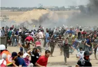  ?? Reuters ?? Palestinia­n demonstrat­ors run for cover from israeli gunfire during a protest marking Al Quds Day at the israel-gaza border in the southern gaza strip on Friday. —