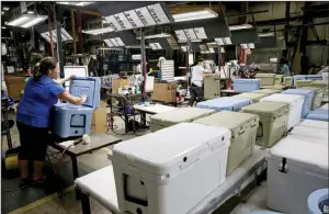  ?? Milwaukee Journal Sentinel/MICHAEL SEARS ?? Employees at Dutchland Plastics work in January on Yeti coolers molded and built by the company in Oostburg, Wis. The coolers are popular with outdoorsme­n and tailgaters.