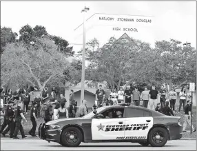  ?? TERRY RENNA/ASSOCIATED PRESS ?? Police patrol in front of Marjory Stoneman Douglas High School in Parkland, Fla., on Feb. 28, as students return to class for the first time since a former student opened fire there with an assault weapon, killing 17 people. Calls to encourage school...