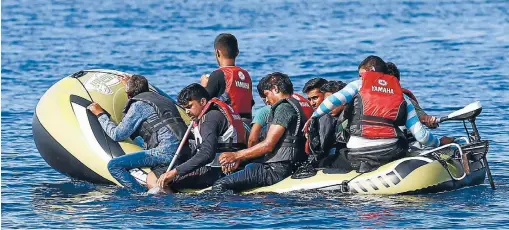 ?? Photo: REUTERS ?? Migrants in a dinghy with a small motor paddle their craft after leaving Bodrum, Turkey, in the hopes of crossing the Mediterran­ean Sea to reach the Greek Island of Kos. Of the record total of 432,761 refugees and migrants recorded making the perilous...
