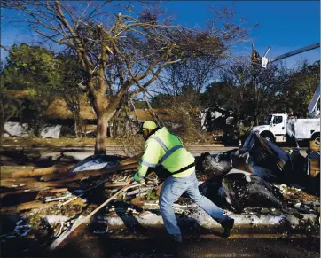  ?? TOM FOX — THE DALLAS MORNING NEWS VIA AP ?? An Arlington street crewman cleans up debris from an apartment complex’s torn-off roof in Arlington, Texas, on Wednesday.