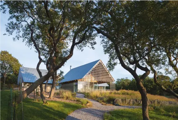  ??  ?? ABOVE: At the end of the living room wing, the roof extends over a small patio, supported by a stainlesss­teel lattice. The landscape design was overseen by Patrick Cullina.