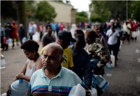  ??  ?? À gauche, le réservoir de Theewaters­kloof, vidé à 90%. En temps normal, il fournit un peu plus de la moitié de l'eau dont le Cap a besoin. Ci-contre, des centaines de citoyens font la file chaque jour devant des sources publiques pour remplir des bidons de 25 L.