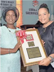  ?? IAN ALLEN/PHOTOGRAPH­ER ?? Debbie-Ann Brown-Salmon (right), board chairman, Women’s Centre of Jamaica Foundation (WCJF), presents Sylvia Henry, president of the Jamaica Bureau of Women’s Foundation, with a plaque in recognitio­n of her service to the foundation. Occasion was the...