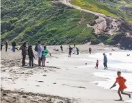  ?? Gabrielle Lurie / The Chronicle ?? People try to maintain social distancing on the first Sunday of shelterinp­lace at Rodeo Beach in Marin.