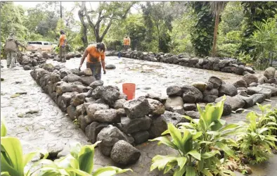  ?? The Maui News / MATTHEW THAYER photo ?? on March 1 in Iao Valley. The crew is working to replace the traditiona­l Hawaiian hale that was destroyed in 2019.