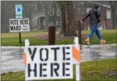  ?? MORRY GASH — THE ASSOCIATED PRESS ?? A voter braves a cold rain running to cast a ballot during the Spring election Tuesday in Fox Point, Wis.