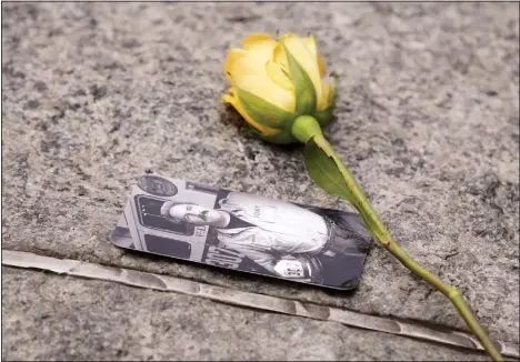 ??  ?? In this May 30, 2019 file photo, a rose rests next to a photograph of New York City Fire Department Lt Steven Reisman in the 9/11 Memorial Glade near the National Sept 11 Memorial & Museum. Reisman searched through the World Trade Center debris for remains, and then died in 2014 of brain cancer at age 54. When the names of nearly 3,000 Sept 11 victims are read aloud on Sept 11, 2019, at the World Trade Center, a half-dozen stacks of stone will quietly salute an untold number
of people who aren’t on the list. (AP)