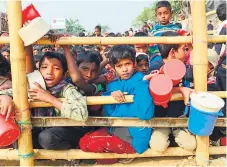  ??  ?? INOCENTES. Grupo de niños rohinyás esperan alimento en un campo de refugiados en Bangladés.