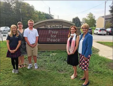  ?? CHAD FELTON — THE NEWS-HERALD ?? Eighth-grader Jordan Leigey, left, with STEM coordinato­r Christine Horne and fellow classmate Ben Matejka at St. Gabriel School on Sept. 20. At right is art teacher Erin Delventhal, in scarf, and Principal Donna Lee Saladino.