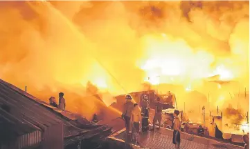  ??  ?? Firefighte­rs extinguish a fire that destroyed hundreds of houses at an informal settlers community in Delpan, Tondo, Manila. — AFP photo