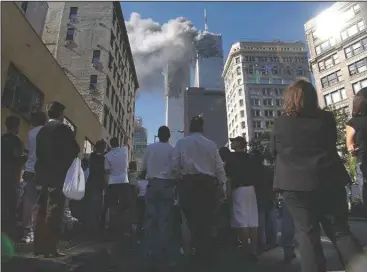  ?? (AP/Amy Sancetta) ?? Pedestrian­s in lower Manhattan watch smoke billow from the World Trade Center on Sept. 11, 2001.