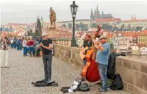  ?? ISTOCK ?? Buskers on Prague’s Charles Bridge.