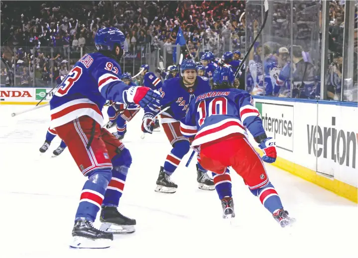  ?? BRUCE BENNETT/GETTY IMAGES ?? New York Rangers forward Artemi Panarin, right, celebrates his game-winning goal against the Pittsburgh Penguins in Sunday's Game 7 in New York.