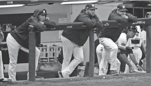  ?? MARK HOFFMAN / MILWAUKEE JOURNAL SENTINEL ?? Some disappoint­ed Brewers watch the Los Angeles Dodgers celebrate their National League Championsh­ip Series victory.