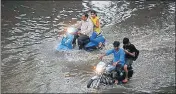  ?? AP ?? Motorists wade through a flooded road in Ahmedabad on Monday.