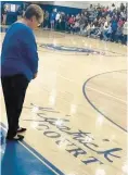 ?? LYNSEY BOSWELL ?? Hall of Fame girls basketball coach Linda Kilpatrick looks at a facsimile of her name on the Southern High School basketball court during a dedication ceremony honoring her and her contributi­ons.