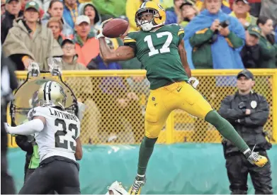  ?? RICK WOOD / MILWAUKEE JOURNAL SENTINEL ?? Packers wide receiver Davante Adams can’t stay in bounds while making a one-handed catch Sunday against the Saints at Lambeau Field.