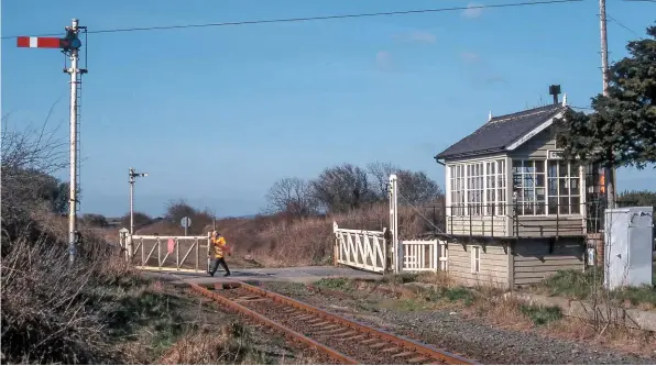  ??  ?? The signaller at Cayton closes the gates for the 1001 Scarboroug­h-Hull train on March 19 1998. The line between Filey and Seamer West was singled in 1983, but a section of the former Up line over the road can be seen. The SB is very large for a gate box - assume it might have been a full block post when it opened in 1908. It was abolished in 2000, and the crossing converted to Automatic Half Barriers.