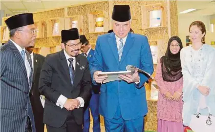  ??  ?? Sultan Nazrin Muizzuddin Shah and Chief statistici­an Dr Mohd Uzir Mahidin reading the 1st Population Census’s publicatio­n in 1891, on Thursday.