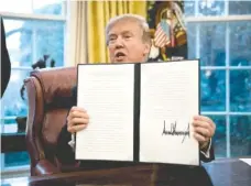  ?? DOUG MILLS/THE NEW YORK TIMES ?? President Donald Trump signs actions placing tariffs on imports of solar energy cells and panels at the White House on Tuesday.