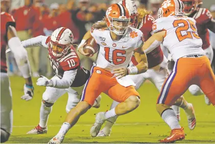  ?? KARL B DEBLAKER/ASSOCIATED PRESS FILE PHOTO ?? Clemson quarterbac­k Trevor Lawrence runs the ball in a November game. ‘Let me make it very clear: Wear a mask and social distance now so we can enjoy high school and college football in South Carolina this fall,’ Gov. Henry McMaster tweeted.