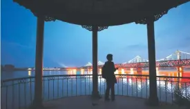  ??  ?? A woman looks out to the China-North Korea Friendship Bridge between the North Korean town of Sinuiju (rear) and Dandong (foreground), in northeast China yesterday. — AFP