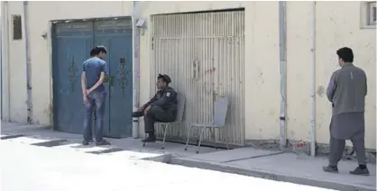  ??  ?? KABUL: A policeman center, sits near the gate of a foreign guesthouse in Kabul, Afghanista­n. —AP