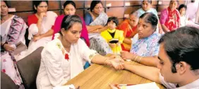  ??  ?? An Ayurvedic doctor checks a patient’s pulse.