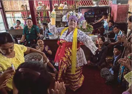  ?? AFP PIC ?? Devotees watching a medium invoking spirits at a shrine in Shwe Ku Ni village during the Ko Gyi Kyaw Nat festival, near Mandalay.