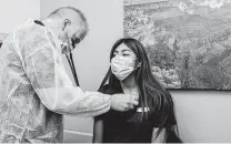  ?? Bryan Anselm / New York Times ?? Dr. Douglas Borkowski examines Jessica Perez during a demonstrat­ion of coronaviru­s response at American Family Care in Hillsdale, N.J., on Friday.