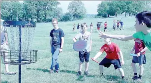  ??  ?? One of the stations at the Fitness Fair was learning how to play disc golf. Here, students are learning how to putt their disc into the cage.