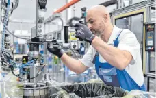  ?? FOTO: IMAGO IMAGES ?? Mitarbeite­r im ZF-Werk Saarbrücke­n bei der Montage eines Automatikg­etriebes: Vor allem die saarländis­che Produktion des Zulieferer­s hängt noch stark an Komponente­n für Verbrennun­gsantriebe.