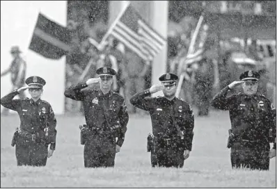  ?? AP/HILARY SCHEINUK ?? Rain falls Monday as members of the Dallas Police Department salute the casket carrying Baton Rouge police Cpl. Montrell Jackson during funeral services in Baton Rouge. On Wednesday, the National Law Enforcemen­t Officers Memorial Fund reported a sharp...