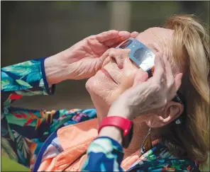  ?? (NWA Democrat-Gazette/J.T. Wampler) ?? Mary McCully of Springdale watches the solar eclipse Monday at the Botanical Garden of the Ozarks in Fayettevil­le. Around 700 people attended the event.