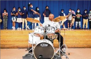  ?? JESSICA GRIFFIN/PHILADELPH­IA INQUIRER/TNS ?? Philadelph­ia police Lt. Jeff Campbell plays the drums as second graders perform during a concert at Hartranft Elementary in North Philadelph­ia. When the music teacher quit, police officers stepped in and gave the kids, and themselves, the chance to learn a lot.