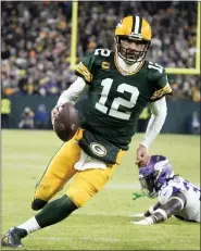  ?? MORRY GASH — THE ASSOCIATED PRESS ?? Green Bay Packers quarterbac­k Aaron Rodgers, left, sprints past Minnesota Vikings linebacker Brian Asamoah II, for a two-yard touchdown run in the Packers’ win Sunday.