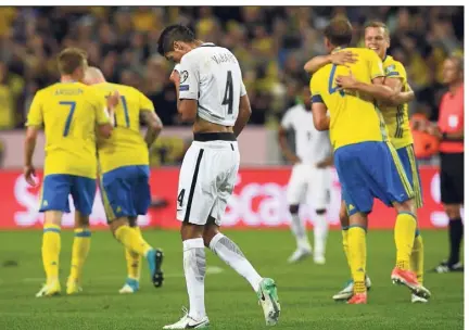  ?? (Photo AFP) ?? Raphaël Varane, déçu, au milieu de Suédois ravis. Drôle de soirée à Solna.