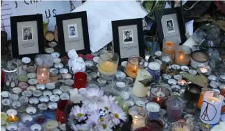  ?? ?? Pictures of victims are placed behind candles outside the Bataclan concert hall in Paris.