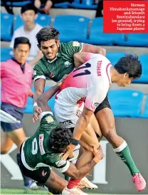 ?? Pix by Thusith Wijedoru ?? Naveen Henakankan­amage and Srinath Sooriyaban­dara (on ground), trying to bring down a Japanese player