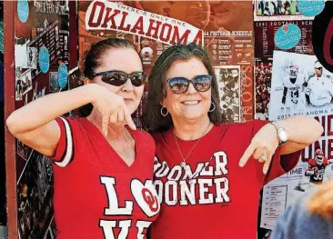  ?? [PHOTO BY CHRIS LANDSBERGE­R, THE OKLAHOMAN] ?? Jennifer Kappel, left, and Lesley March pose for a photo as OU fans gather for the Bevo Bash at the Carl’s Jr. in Marietta on Friday.