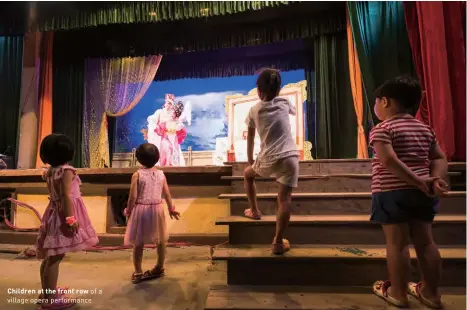  ?? ?? Children at the front row of a village opera performanc­e